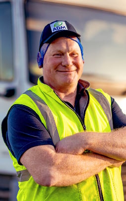 An ADM driver stands in front of his truck 