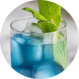 A glass of a bright blue beverage with an herb garnish