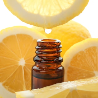 To A bottle of essential oil surrounded by lemon slices