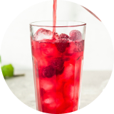 A glass of red iced hibiscus tea made with a naturally derived color solution