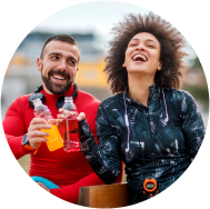 A couple enjoying fruit flavoured red and yellow color drinks in their hands