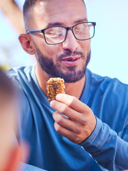 man with glasses eating snack
