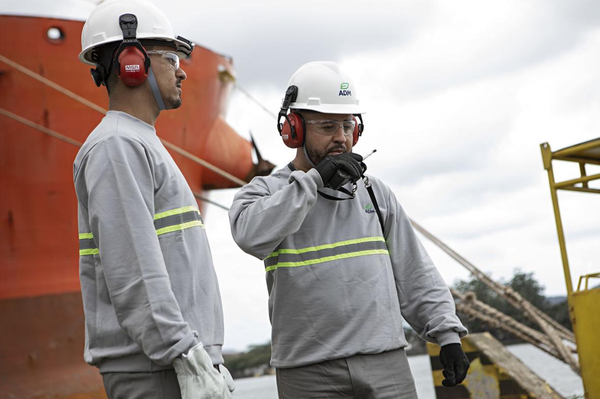 Two man standing in boat dock holding walkie talkie ADM Port Facility 0336v1 lores