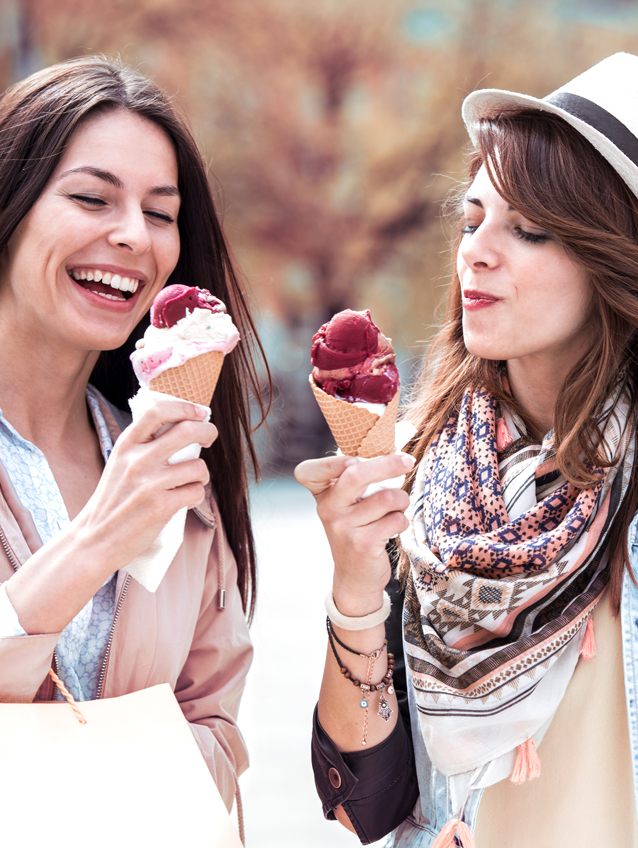 Two beautiful girls Women eating flavourful and colorful ice cream and shopping 