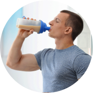 A fit man drinking a protein shake from a bottle.