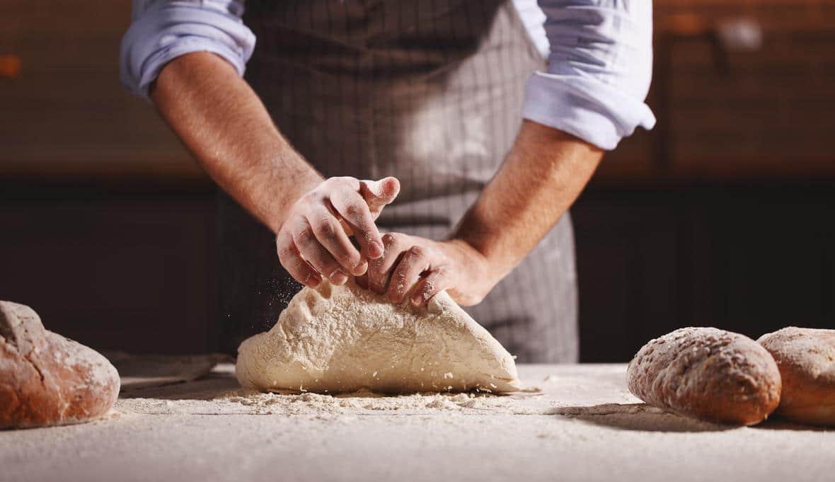 Baker kneading bread dough