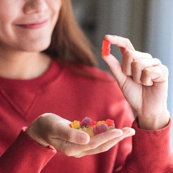 A woman is analyzing a red pill, dietary supplement