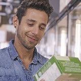A man reads the back of a green package box