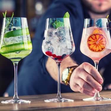 bartender lining up cocktails on bar